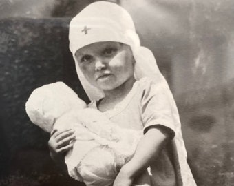 Vintage black and white photo child with doll and nurses costume Antique Halloween photo