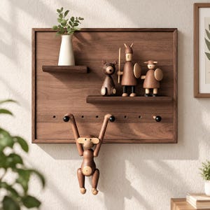 May include: A rectangular wooden wall shelf featuring a small white vase with greenery, three wooden figurines of a bear and two warriors, and a hanging wooden monkey toy. The unit includes multiple pegs for storage and a dark wood finish.