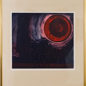 Puede incluir: Una impresión enmarcada con un fondo oscuro y texturizado que presenta una gran forma circular de color rojo vibrante en la parte superior derecha. La composición incluye líneas tenues en forma de cuadrícula que sugieren una estructura.