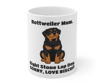 May include: A white ceramic mug featuring a cartoon illustration of a black and tan Rottweiler dog. The text above the dog reads "Rottweiler Mum." and the text below reads "Eight Stone Lap Dog. SORRY, LOVE BISCUIT" in bold black lettering.