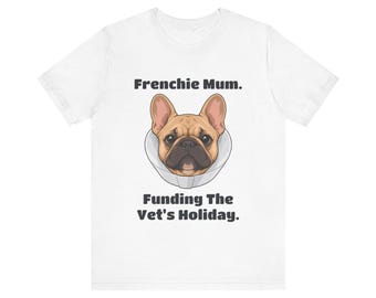 May include: A white t-shirt featuring a graphic of a tan French Bulldog wearing a white plastic cone collar. Above the dog is the text Frenchie Mum. and below the dog is the text Funding The Vet's Holiday. The design is centered on the chest.