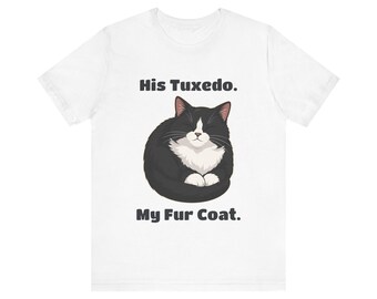 May include: A white short-sleeved t-shirt featuring a graphic of a black and white tuxedo cat curled up with its eyes closed. Above the cat is the text His Tuxedo. and below the cat is the text My Fur Coat. in a dark gray sans-serif font.