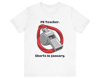 May include: A white t-shirt featuring a graphic of a silver whistle with a red lanyard. The text above the whistle reads "PE Teacher." and the text below the whistle reads "Shorts In January." The design is centered on the front of the shirt.