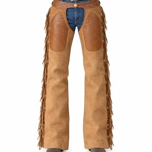 Peut inclure: Chaps en cuir suédé beige avec des empiècements de cuisse en cuir marron lisse, de longues franges sur les côtés extérieurs et des clous métalliques argentés. Les chaps sont portées sur un jean bleu avec une ceinture en cuir marron et des bottes.