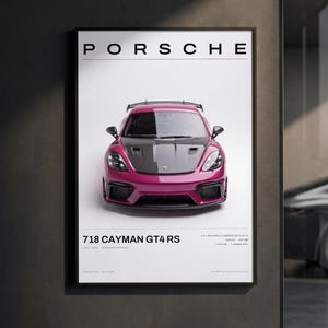 May include: A framed vertical poster featuring a magenta Porsche 718 Cayman GT4 RS with a dark hood. The text PORSCHE appears at the top, with 718 CAYMAN GT4 RS and technical specifications including 4.0L NATURALLY ASPIRATED FLAT-6 printed below.