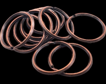 May include: A pile of copper-colored key rings. The rings are all the same size and are arranged in a random pattern.
