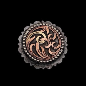 May include: Ornate silver-toned metal button with a central design in copper and gold. The button features a detailed, swirling pattern within a circular frame, surrounded by a beaded border and a scalloped edge. The background is black.