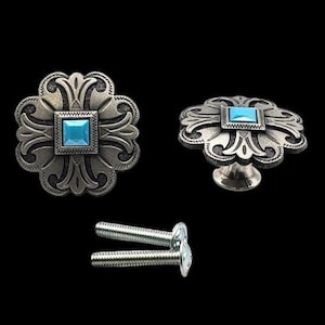 May include: Two silver-toned cabinet knobs with a turquoise stone in the centre. The knobs have a decorative floral design. The knobs come with two screws.