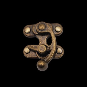 May include: Antique brass-toned metal clasp with a rounded knob and a swiveling latch. The clasp has four decorative rivets.
