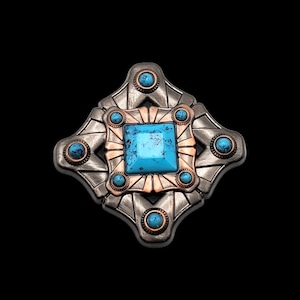 May include: A silver and copper coloured metal pendant with a turquoise stone in the centre and smaller turquoise stones around the edges. The pendant is shaped like a diamond.
