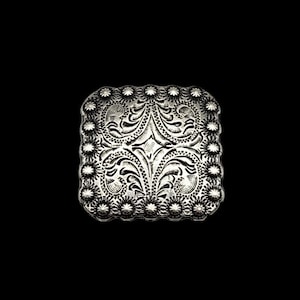 May include: A silver square-shaped metal buckle with a floral design and a raised border.