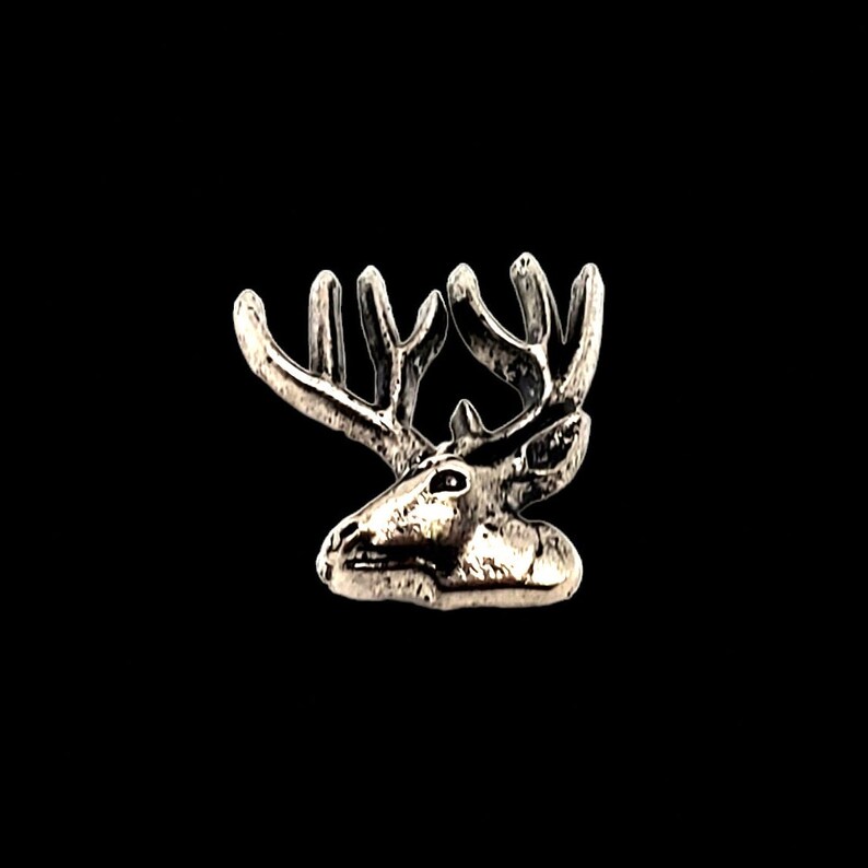 May include: A silver-toned deer head charm with detailed antlers.