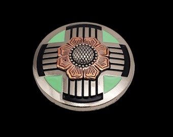 May include: A silver and black metal belt buckle with a green and copper flower design.