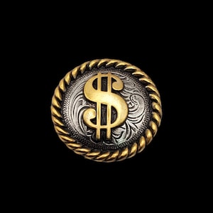 May include: A round, gold and silver-toned metal button with a dollar sign in the center. The dollar sign is gold, and the background is silver with an engraved floral design. The button has a gold rope-like border.