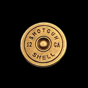 May include: A gold-colored shotgun shell with the text "SHOTGUN SHELL 12 GA" printed on it.