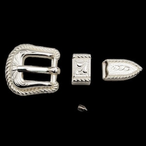 Pode incluir: Conjunto de fivela de cinto prateada com um design de corda decorativo. O conjunto inclui uma fivela, um prendedor, uma ponta e um parafuso.