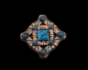May include: A copper-toned metal pin with a geometric design featuring a central turquoise stone and six smaller turquoise stones around it.