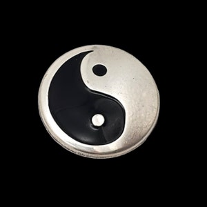 May include: A silver-toned pendant with a black and white yin yang symbol.
