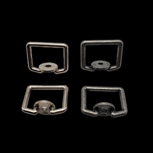 May include: Four metal D-ring hardware pieces. Two are silver and two are antique silver.
