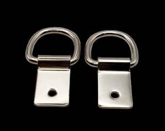 May include: Two silver metal D-rings with a rectangular plate attached to each ring. The plates have a small hole in the center.
