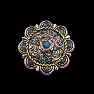May include: A silver, copper, and gold-toned metal decorative button with a floral design. The button features a central turquoise stone surrounded by a copper flower. The outer edge has turquoise stones and a gold rope-like trim. The background is black.