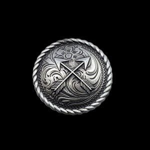 以下が含まれることがあります： ロープ状の縁取りと、花柄の背景に2本の交差した矢印のデザインが施された銀色の金属製のベルトバックルです。