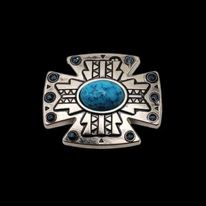 May include: A silver-toned cross-shaped pendant with a turquoise stone in the center. The cross has a geometric design with small blue stones around the edges.