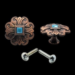 May include: Two decorative bronze-colored cabinet knobs with a turquoise square center stone. The knobs have an ornate floral design and come with silver screws for installation. One knob is shown from the side.