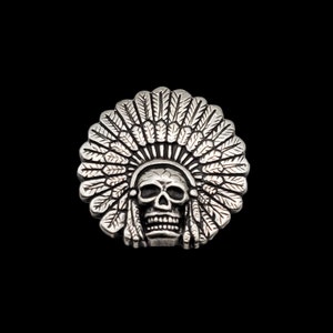 May include: Silver skull wearing a headdress with feathers.