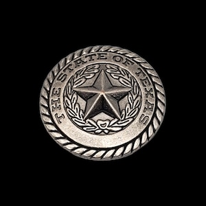 May include: A silver-toned metal button with a rope-like border. The button features the state seal of Texas, which includes a five-pointed star surrounded by a laurel wreath. The text "THE STATE OF TEXAS" is inscribed around the border.