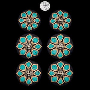 May include: A set of six circular cabinet knobs featuring a black base and a central flower design. Each knob has eight turquoise-colored petal inlays framed in metallic gold, with a small, textured silver-toned dome at the very center of each.