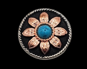 May include: A silver and black button with a copper flower design and a turquoise stone in the center.