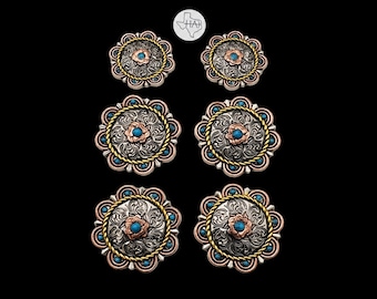 May include: Six circular concho buttons arranged in three pairs of varying sizes. Each button features a silver-toned floral engraved center, a copper-toned flower accent with a turquoise stone, a gold-toned rope border, and turquoise accents.