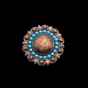 May include: A round, copper-coloured metal concho with a floral design and a turquoise bead border.