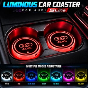 May include: Two circular luminous car coasters for Audi SLine vehicles, featuring the Audi logo in red light. Below, a grid displays the coaster in seven adjustable colour modes: white, red, dark blue, green, ice blue, pink, and yellow.