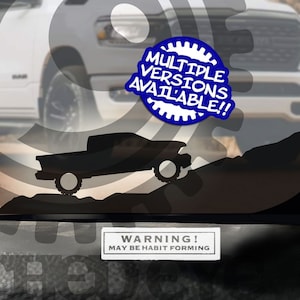 May include: A white truck with a black silhouette of a truck decal on the windshield. The decal is sold separately. The text "The Best Micro Decals in the System" is at the top of the image. The text "Clothedeye Better Than The Naked Eye" is at the top right of the image. The text "Multiple Versions Available!" is in a blue circle with a gear design. The text "Sold Separately" is at the bottom left of the image. The text "Warning! May Be Habit Forming" is at the bottom of the image. The text "Suggested Placement" is at the bottom of the image. The text "All Designs Copyright © Clothedeye, LLC Characters and Vehicles are Trademarks and Copyright of Their Affiliated Owners" is at the bottom of the image.