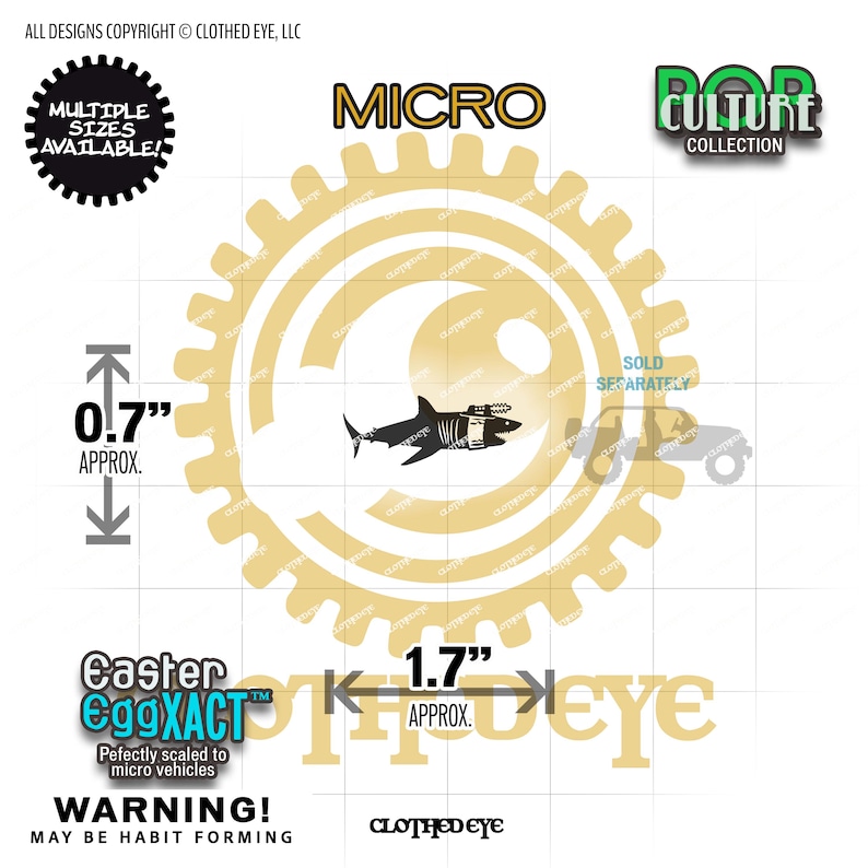 May include: A black shark silhouette sticker with a mechanical attachment, featuring text including MICRO, POP CULTURE COLLECTION, and Easter EggXACT. The design includes dimension markers indicating approximately 0.7 inches in height and 1.7 inches in width.