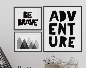 May include: Black and white nursery decor with a teepee tent, a stuffed reindeer, and three framed prints. The prints feature the words "Be Brave", "Adventure", and a geometric mountain design.