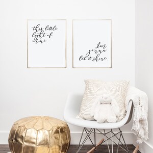 Pode incluir: Duas impress&otilde;es emolduradas com molduras douradas e fundos brancos. O texto nas impress&otilde;es diz "This little light of mine" e "I'm gonna let it shine". Uma cadeira de balan&ccedil;o branca com um travesseiro estampado em dourado e um coelho de pel&uacute;cia branco. Um pufe dourado fica em cima de um tapete branco e felpudo.