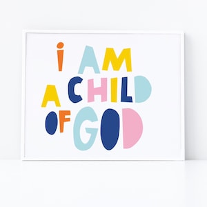 Puede incluir: Una impresión enmarcada en blanco con el texto "I AM A CHILD OF GOD" en letras negritas y coloridas. Las letras son de varios colores, incluyendo amarillo, naranja, rosa, azul y azul claro.