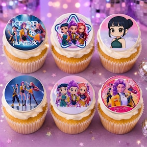 May include: Six cupcakes topped with circular edible decorations featuring K-pop inspired illustrations. The designs include groups of three characters in colorful outfits, a single character portrait, and text reading KPOP HUNTRAX and Happy Birthday.