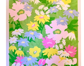 May include: A colourful floral art print showcasing paper-cut flowers in pink, yellow, blue, and white, set against a green backdrop. The artwork is framed with a white border, creating a cheerful and vibrant composition, suitable for home decor.