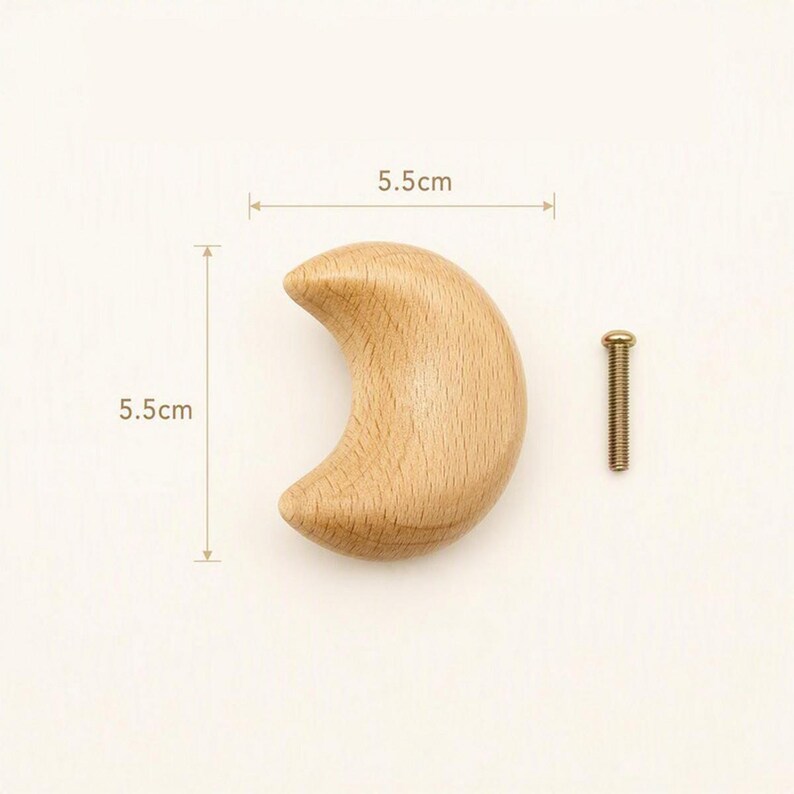 May include: A crescent moon-shaped wooden knob with a light tan wood grain finish. The knob measures 5.5 cm in width and 5.5 cm in height. A single metal screw with a threaded shaft and a flat head is positioned to the right of the wooden knob.