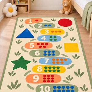 Könnte beinhalten: Ein rechteckiger Teppich mit einem Hüpfspiel-Design auf cremefarbenem Hintergrund. Der Teppich zeigt die Zahlen eins bis zehn in bunten, abgerundeten horizontalen Segmenten, jeweils begleitet von einer entsprechenden Anzahl an Punkten und grünen Blattmotiven.