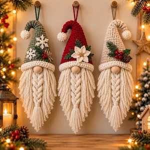 May include: Three hanging crochet gnome ornaments with long braided cream-colored beards and wooden bead noses. The left gnome has a green hat with white snowflakes, the center has a red hat with a white poinsettia, and the right has a beige hat.