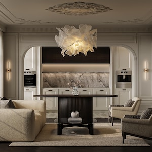 May include: A dining room featuring a dark brown oval table with a fluted base, surrounded by a cream-colored textured sofa and two matching armchairs. A large, translucent, ruffled white pendant light hangs above the center of the table.