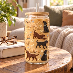 Labrador Retriever pattern glass cup with bamboo lid and glass straw in an everyday scene.