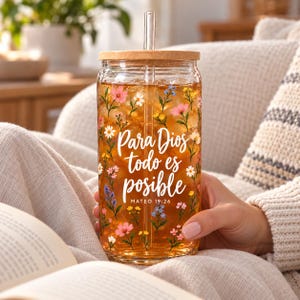 May include: A clear glass tumbler with a bamboo lid and glass straw, filled with amber liquid and ice. The exterior features a colorful floral pattern and the white script text Para Dios todo es posible MATEO 19:26.