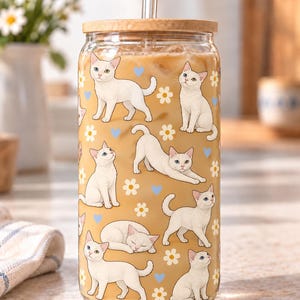 Example of a white cat pattern with different colored eyes, repeated around a clear glass with ivory flowers and blue hearts.