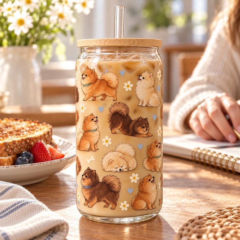 Pomeranian pattern glass cup with bamboo lid and glass straw in an everyday scene.
